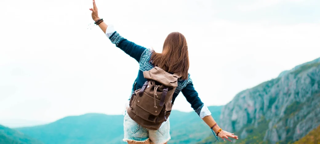 A woman on a mountain feeling free after donating her eggs.