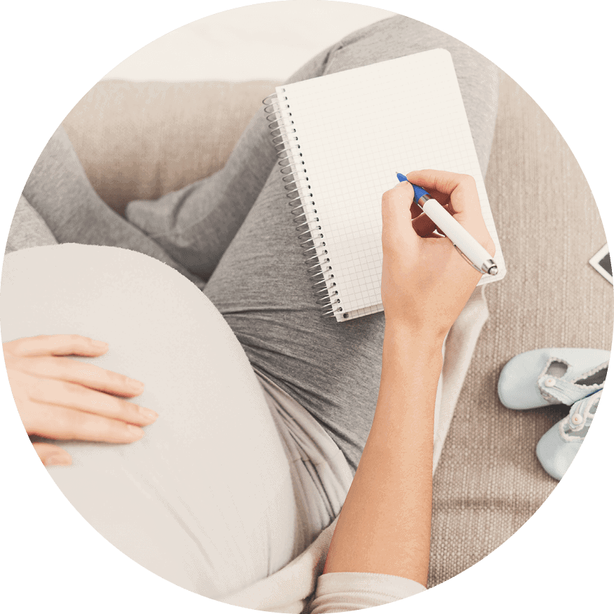 A pregnant woman writes in her notebook, documenting her thoughts on working with Fairfax EggBank to get pregnant.