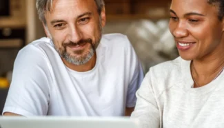 Egg donor recipients looking at Fairfax EggBank's success rates on their laptop.