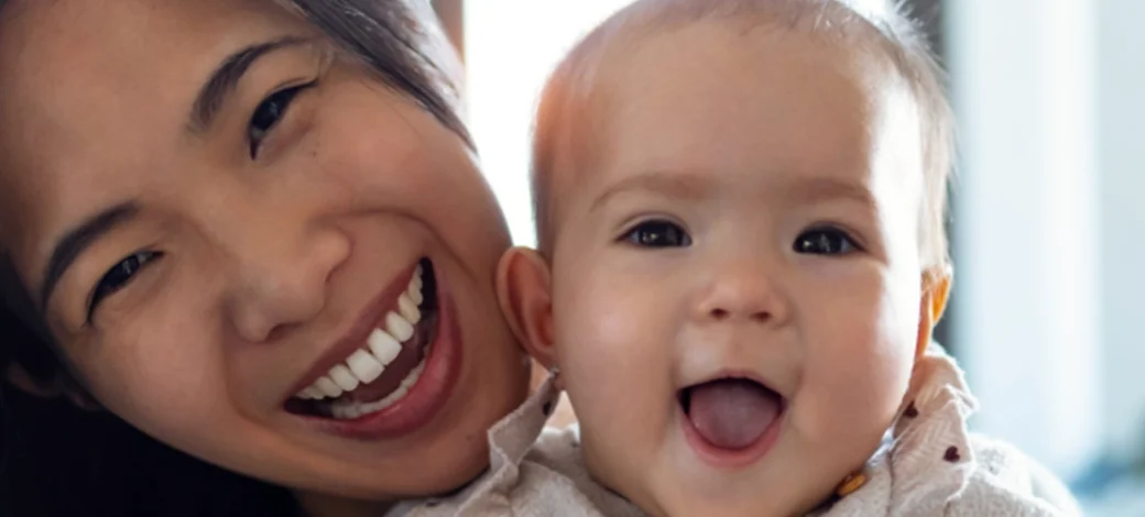 Egg donor recipient holding up her egg donor conceived baby, happy with her decision to use donor eggs.
