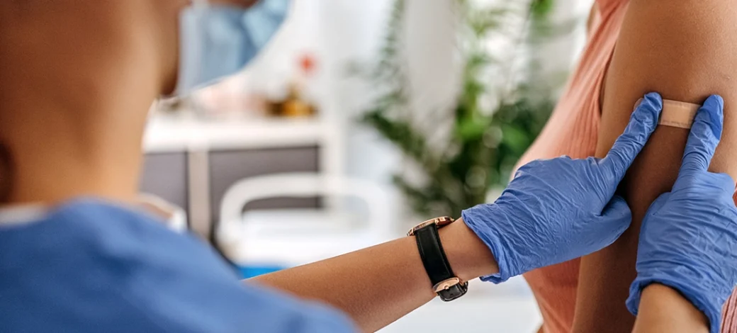 Woman at the doctors getting her COVID shot wondering if it will affect her fertility.