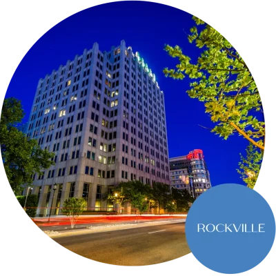 A view of the city in Rockville and Bethesda, MD, with buildings lit up and cars passing by in the foreground. Become an egg donor in Maryland today!